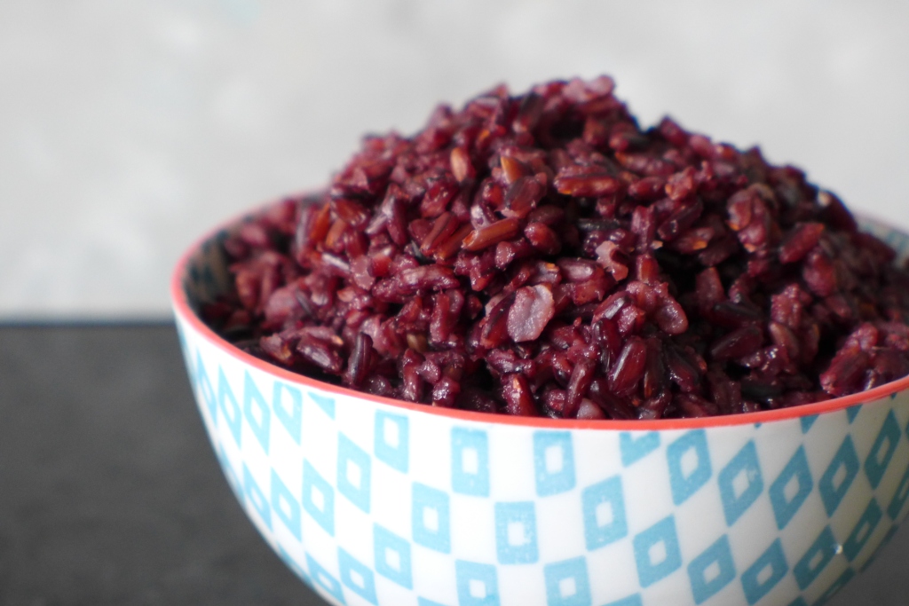 cooked black rice in blue and white ceramic bowl